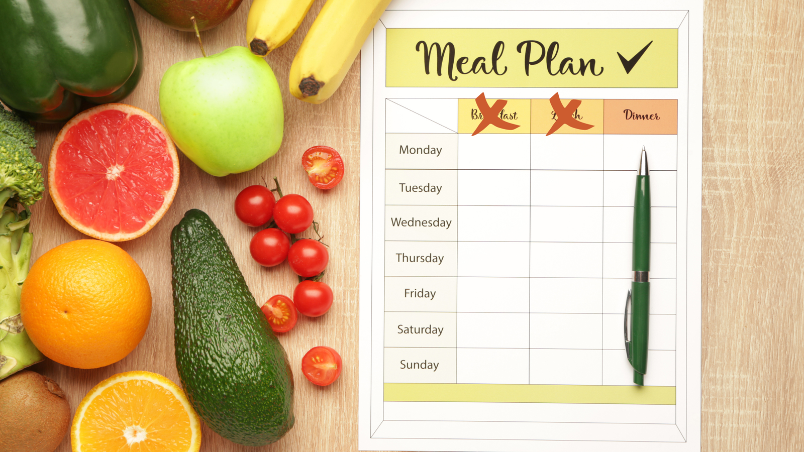 A OMAD meal plan featuring an assortment of fruits and vegetables arranged on a wooden table.